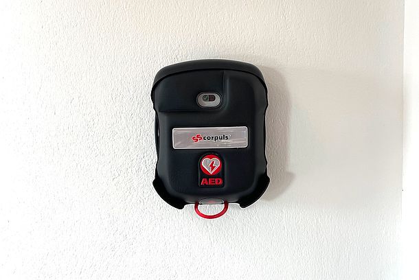 Wandmontierter AED in schwarzer Tasche am Eingang zum Stahllager