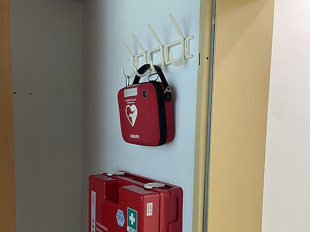 Erste Hilfe Raum, rechts vor den Damentoiletten, AED links von der Tür an der Garderobe