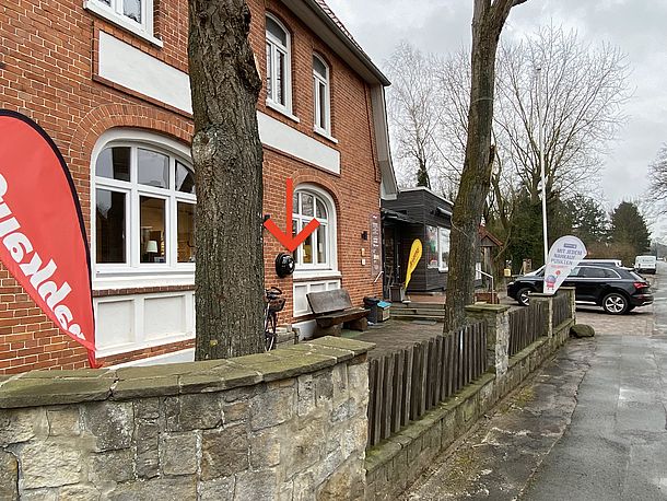 AED im runden Wandkasten am verklinkerten Hausteil des Dorfladens