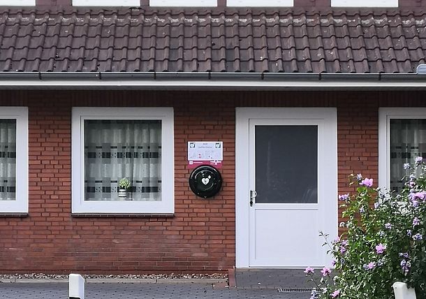 Öffentlicher AED im runden Wandkasten links neben dem Eingang zum Dorfgemeinschaftshaus Öffentlicher AED im runden Wandkasten links neben dem Eingang zum Dorfgemeinschaftshaus