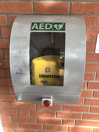 wandmontierter AED rechts von der Haupteingangstür zur JUH Geschäftsstelle, Ecke Vagesweg