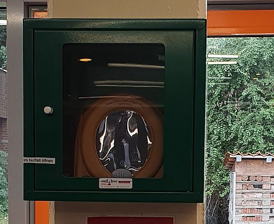 AED im grünen Wandkasten AED im grünen Wandkasten
