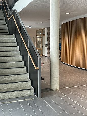 Rechts an der Treppe vorbei Richtung Mensa/Hausmeister