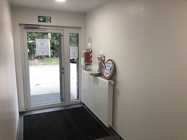 Wandmontierter AED direkt hinter der Eingangstür links an der Wand Wandmontierter AED direkt hinter der Eingangstür links an der Wand