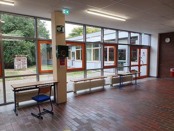 Eingangshalle, AED im wandmontierten Kasten an der Säule Fenster zum Innenhof Eingangshalle, AED im wandmontierten Kasten an der Säule Fenster zum Innenhof