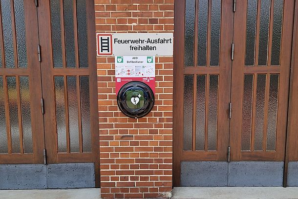 Öffentlicher AED im schwarzen Wandkasten